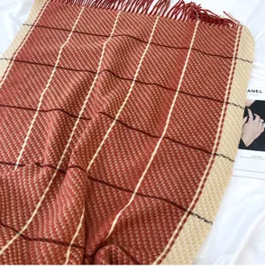 Close-up detail of the cozy winter plaid cashmere-feel scarf featuring soft tassels and texture.