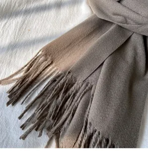 Nahaufnahme eines weichen braunen, gemusterten Strickschals mit Fransen für den Winter.