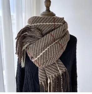 Detailed close-up showing the soft brown woven texture and stylish fringe of the warm winter scarf.