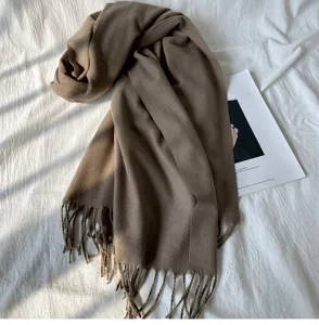 Detailansicht eines kuscheligen, einfarbigen Winterschals mit Fransen in elegantem Design.