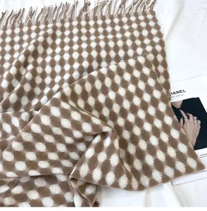 Detailed view of the brown and white patterned knit scarf featuring soft tassel edges and cozy fabric.