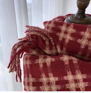 Close-up of red winter plaid scarf with fringe, soft textured wool-feel warm neck wrap.