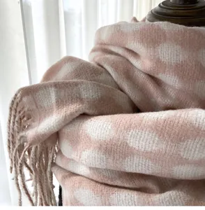 Close-up detail of soft pink and white checkered imitation cashmere scarf with cute fringe.