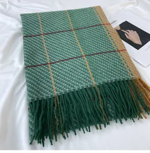 Detailed close-up view of the green plaid winter scarf featuring soft texture and stylish fringe.