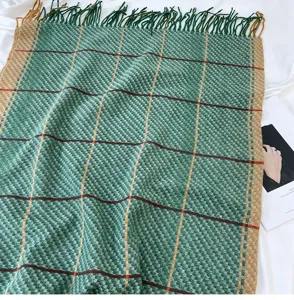 Detail view of a cozy green plaid tassel scarf, perfect for autumn and winter daily wear.