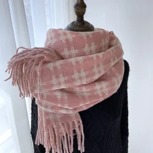 Close-up detail view of the stylish pink grid knitted winter scarf showing soft fringe ends.
