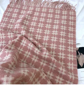 Detail view of pink plaid cashmere-feel winter scarf featuring soft fringe and elegant vintage grid pattern.