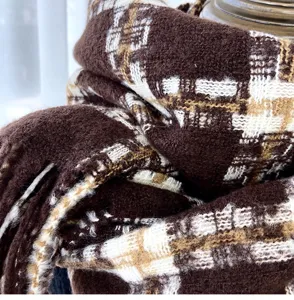 Detailed close-up of brown plaid imitation cashmere scarf, showing soft winter warm knitted texture.