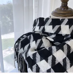 Detail shot of black and white houndstooth scarf with tassels, soft and warm accessory.