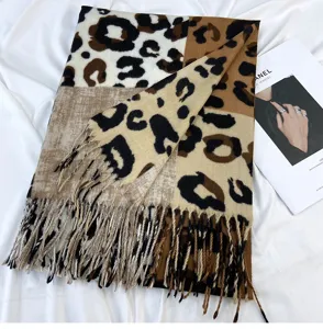 Close-up detail of women winter color-blocked leopard print imitation cashmere scarf with tassels.