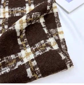 Close-up view of brown and white plaid winter scarf, showing soft texture and cozy fabric.