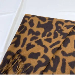 Detailed view of women's winter imitation cashmere leopard print scarf with stylish fringe.