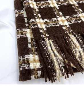 Closeup of autumn winter plaid scarf, soft imitation cashmere texture with warm tassel edge.