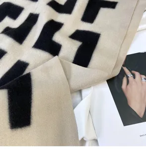 Chic beige and black geometric print cashmere-feel winter scarf detail view, cozy shawl.