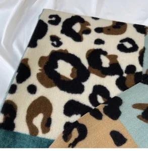 Close-up detail of cozy color-block leopard print imitation cashmere winter scarf.