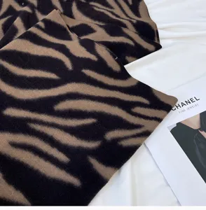 Close-up detail of cozy brown and black zebra stripe imitation cashmere scarf texture.