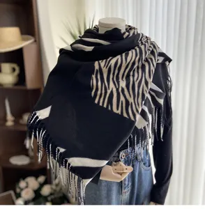 Detailed view of the women's black and white zebra pattern imitation cashmere scarf with tassels.