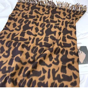 Leopard print faux cashmere scarf detail showing soft texture and stylish fringe design.