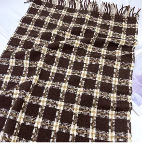 Detailed view of the cozy brown plaid winter scarf with soft texture and chic fringe trim.