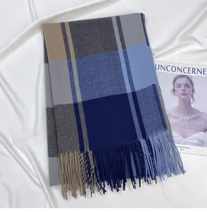 Detailed shot of a blue and brown plaid scarf featuring soft cashmere-feel fabric and tassels.
