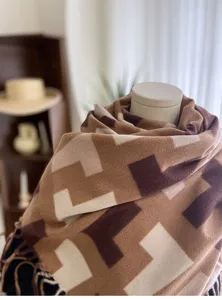 Detailed close-up view of the geometric patterned warm scarf showing soft texture and tassels.