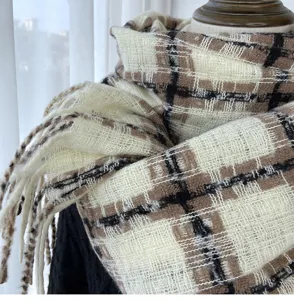 Close-up detail shot of soft imitation cashmere plaid scarf featuring elegant fringe tassels.