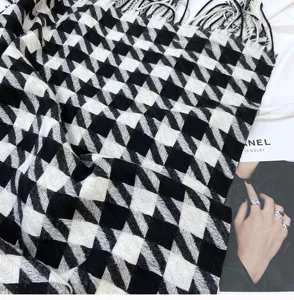 Close-up view of black and white houndstooth cashmere-feel tassel scarf detail texture.