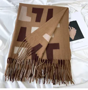 Detail view of winter warm cashmere-feel tassel scarf with geometric color block pattern.