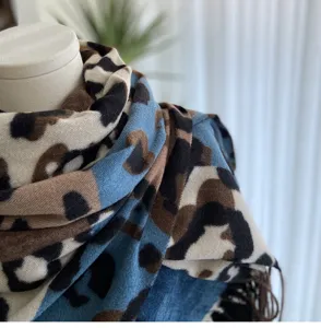 Close-up detail of women's autumn winter colorblock leopard print cashmere scarf with fringe shawl