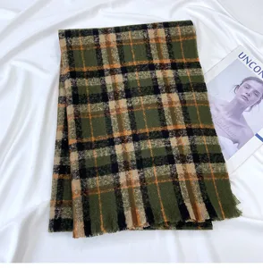 Detailed view of green plaid winter scarf with soft fringe texture in lifestyle setting