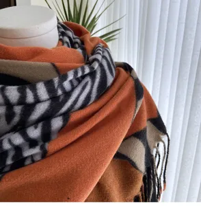 Detailed view of the faux cashmere zebra pattern scarf, featuring soft fringe and warm texture.