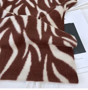 Brown and white zebra print scarf detail showing soft imitation cashmere texture and drape.