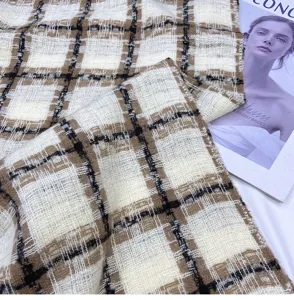 Detailed shot of autumn winter plaid scarf fabric, classic black white brown tweed pattern.