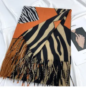 Cozy imitation cashmere scarf featuring bold orange and zebra print design with chic tassels.