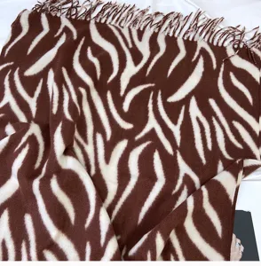 Close-up detail of the cozy brown and white zebra print fringe cashmere-like shawl scarf.
