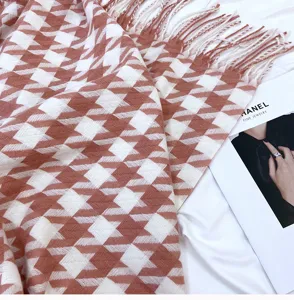 Close-up details of stylish houndstooth scarf with cute tassels, warm soft cashmere.
