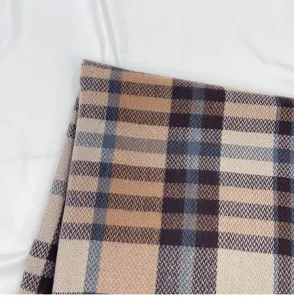 Close-up detail of classic winter plaid cashmere-feel scarf fabric texture pattern.
