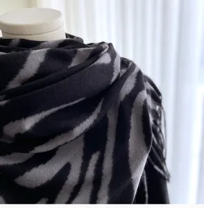 Close-up of black and grey zebra print winter scarf tassel cashmere feel detail knit wrap