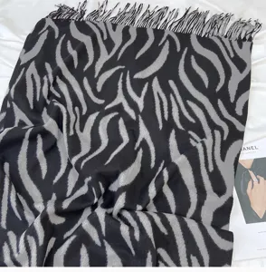 Close-up detail of black and grey zebra pattern tassel cashmere-feel winter scarf shawl.