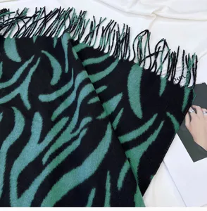 Detailed shot of a black and green striped tassel scarf, soft winter warm wrap shawl.