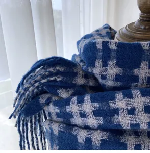 Detail view of blue and grey plaid imitation cashmere scarf showing soft texture and fringe.