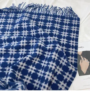 Blue plaid woven tassel scarf detail view showcasing soft winter pattern and texture.