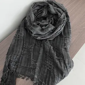 Dark grey distressed woven scarf detail, lightweight gauze shawl texture close-up