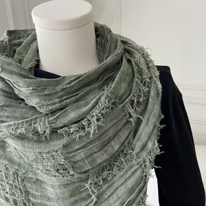 Detailed close-up of sage green crinkled frayed scarf showing soft texture and lightweight design.