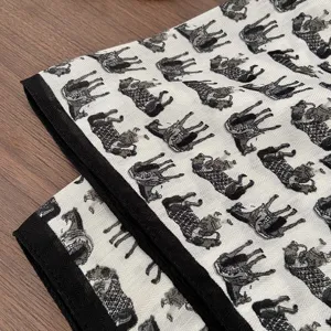 Close-up detail of vintage horse print cotton linen square scarf with elegant black border.