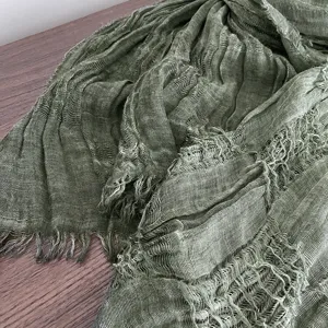 Detailed close-up of the green crinkled gauze scarf showing soft fringe and delicate texture.