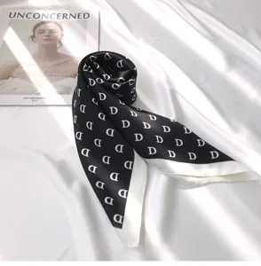 Detailed view of a black and white silk square scarf with D letter print for women.