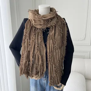 Detailed view of the brown distressed tassel scarf, featuring lightweight gauze details.