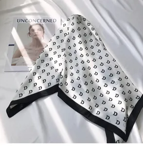 Elegant black and white monogram silk square scarf, versatile fashion neckwear accessory.