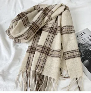 Cozy beige and brown plaid scarf detail, featuring soft fabric texture and elegant fringe ends.